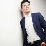 Elegant businessman in a blue suit looking thoughtful, ideal for corporate themes.